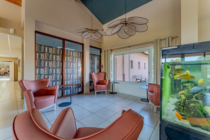 Coin lecture avec fauteuils et aquarium à la Résidence Pagomal